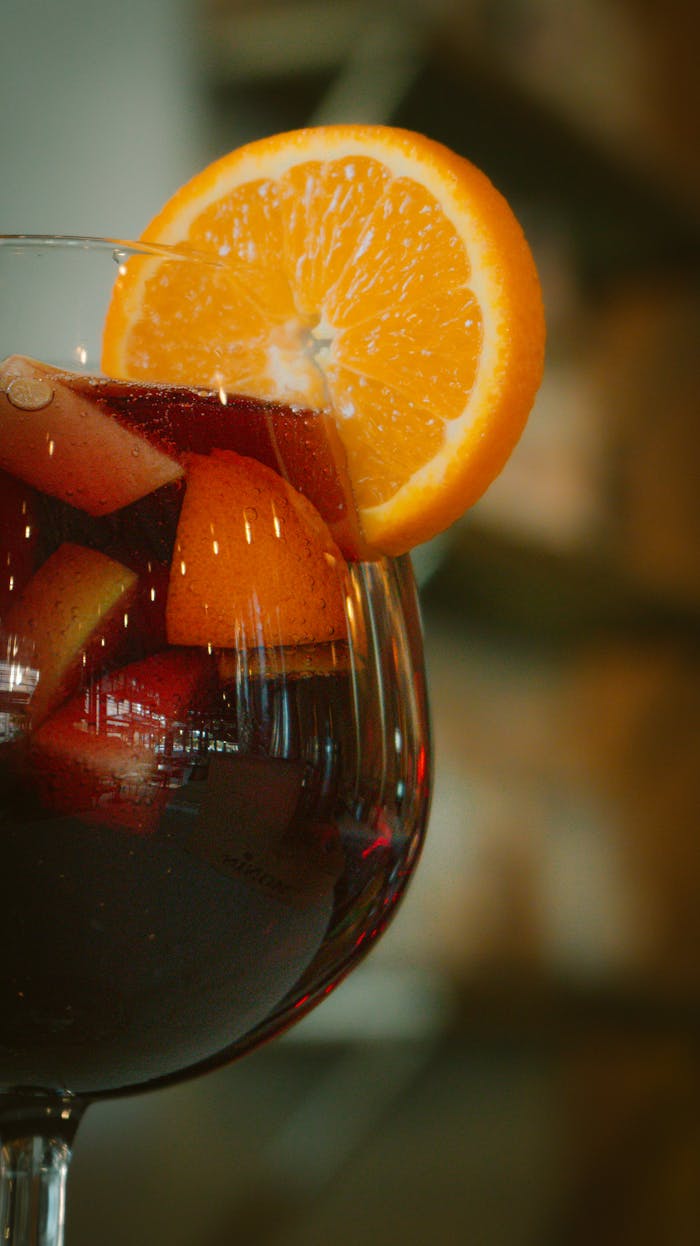 Delicious sangria filled with fresh orange and apple slices in a wine glass.